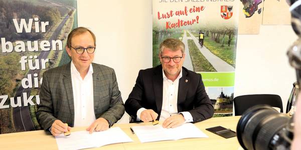 Landrat Markus Bauer und Oberbürgermeister Bert Knoblauch bei der Unterzeichnung der Vereinbarung.