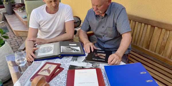 Enkel Matthias und Sohn Arnim Malkowsi blättern in Fotoalben zu ihrem Opa beziehungsweise Vater Dario Malkowsi.