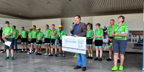Uwe Scholz, stellvertretender Oberbürgermeister, präsentiert den Scheck über 12.900 Euro, die bei einem Charityevent in der weltrad manufactur gesammelt worden.