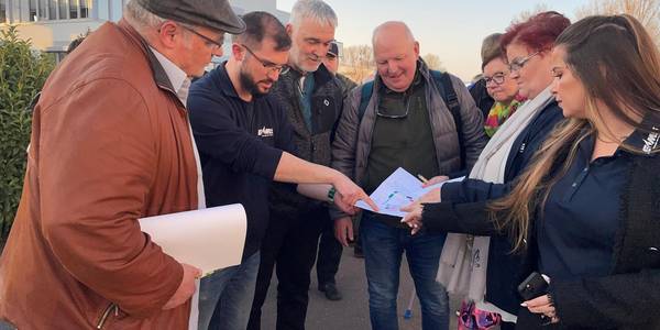 Die EMS-Mitarbeiter Manuela Jäger (2. v.r.) und Sebastian Rabach (2. v.l.) erläutern am Plan, wo welche Stände auf dem EMS-Firmengelände platziert werden.