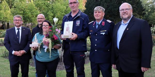 Sechs Personen stehen auf dem Rasen, im Hintergrund das Gradierwerk mit Mühlenturm.