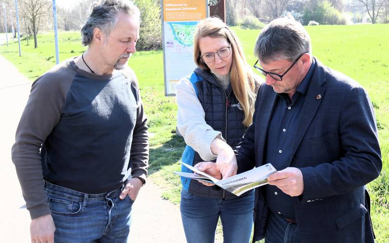 Anna Orling stellt Wirtschaftsförderer Sven Ellert (l.) und Oberbürgermeister Bert Knoblauch das neue Infoheft zum Elberadweg vor.