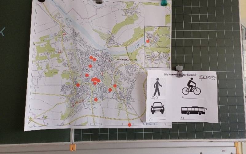Eine Straßenkarte hängt an der Tafel.